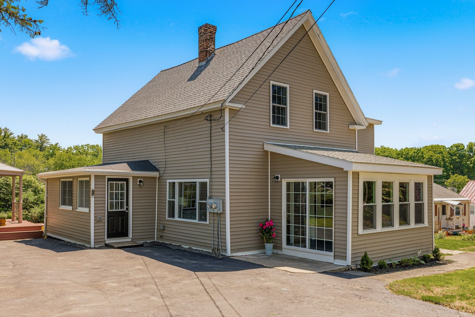 Front approach to the historic side with its enclosed sunroom and chimney